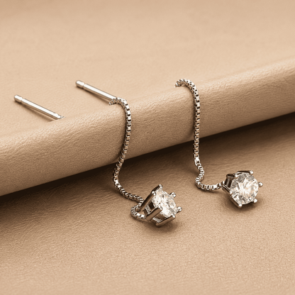 silver chain threader earrings on beige leather background
