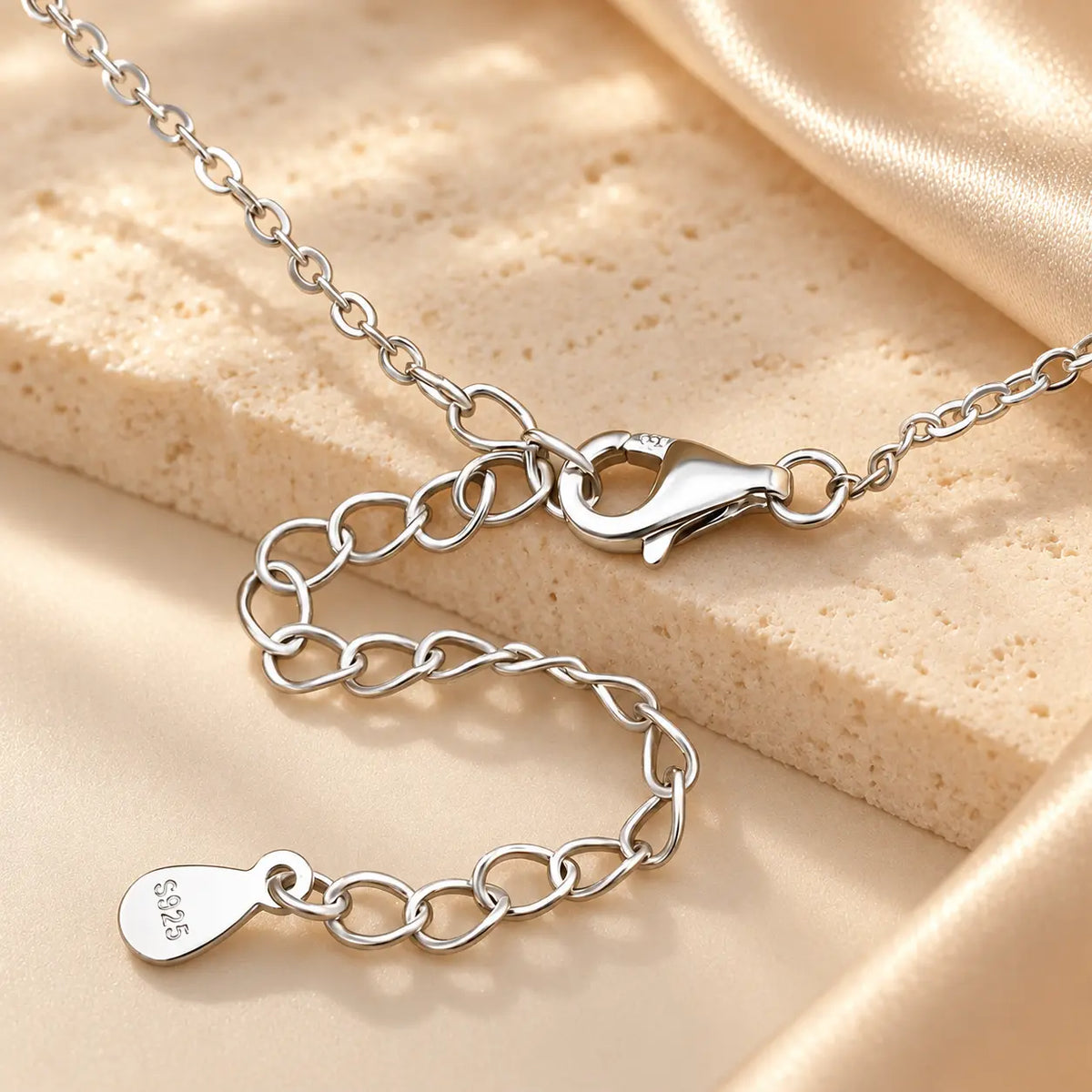 Hand holding a silver tone moissanite Y necklace showing the delicate stone-set drop