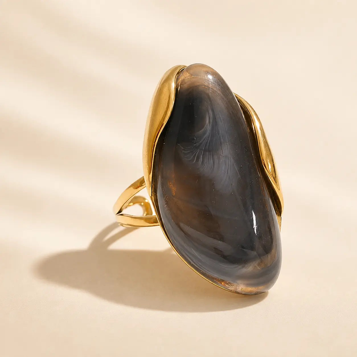 Black Solenne™ resin statement ring for women featuring a glossy dark finish and polished gold-tone details.
