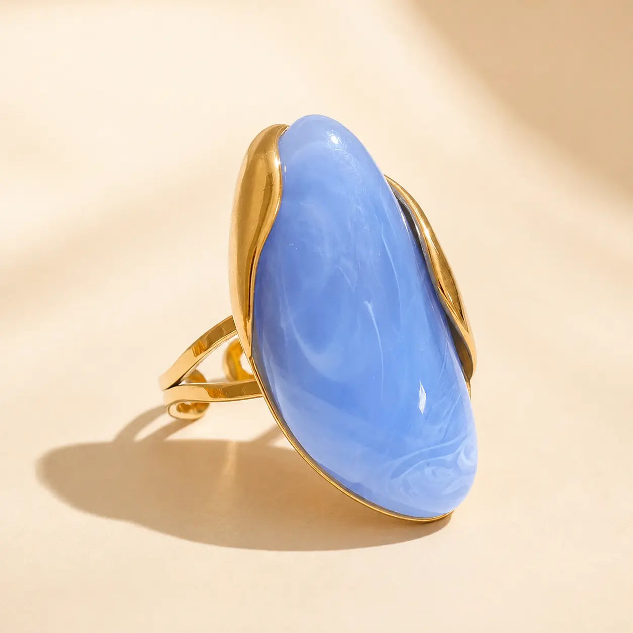 Blue Solenne™ resin statement ring for women featuring a glossy finish and modern gold-tone sculptural setting.