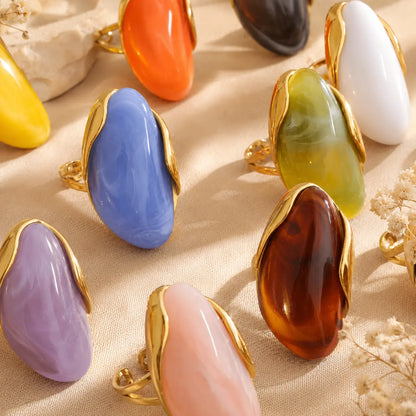 Solenne™ Color Resin Statement Ring for Women shown in multiple vibrant colors with polished gold-tone stainless steel details.