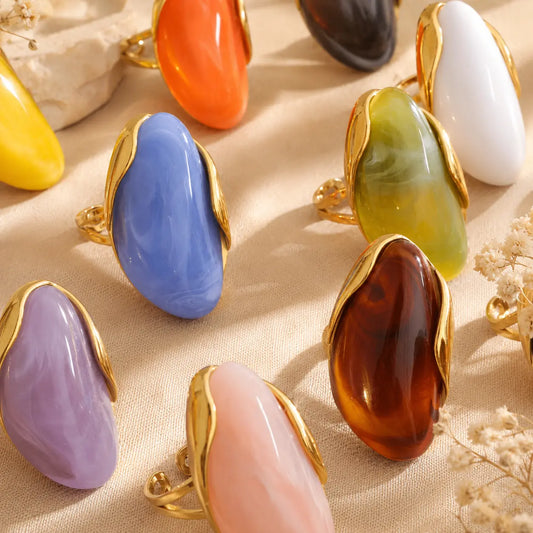 Solenne™ Color Resin Statement Ring for Women shown in multiple vibrant colors with polished gold-tone stainless steel details.