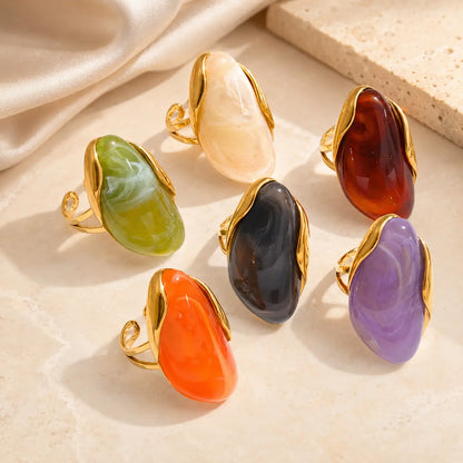 Solenne™ Color Resin Statement Ring for Women shown in multiple vibrant colors with polished gold-tone stainless steel details...