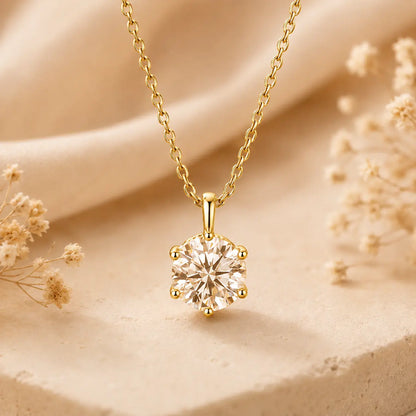 Yellow gold round moissanite pendant necklace styled in a warm beige setting